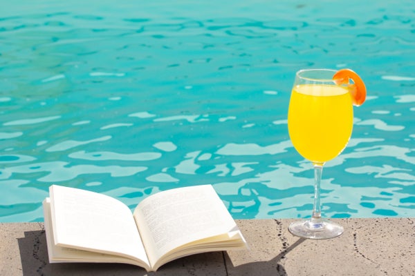 Open book and orange drink poolsid