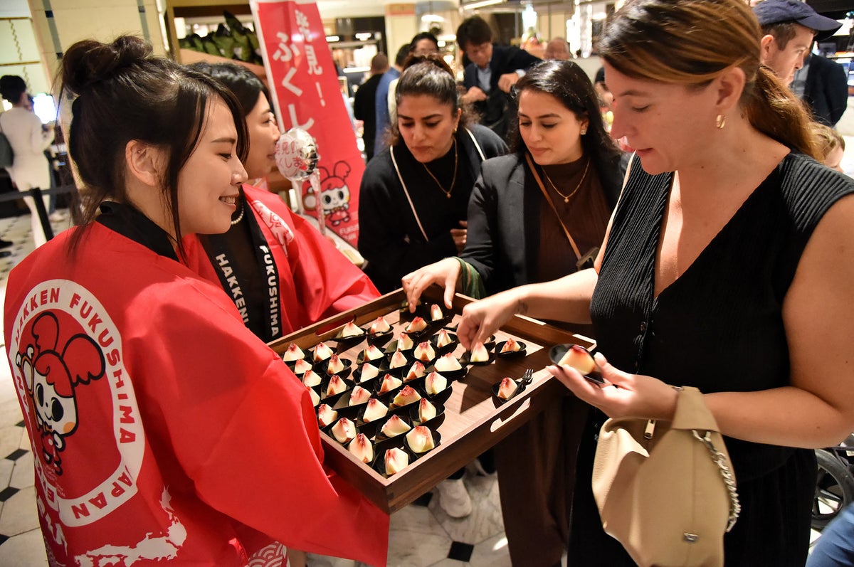 Customers sample peaches from Japan's Fukushima prefecture at Harrod's.