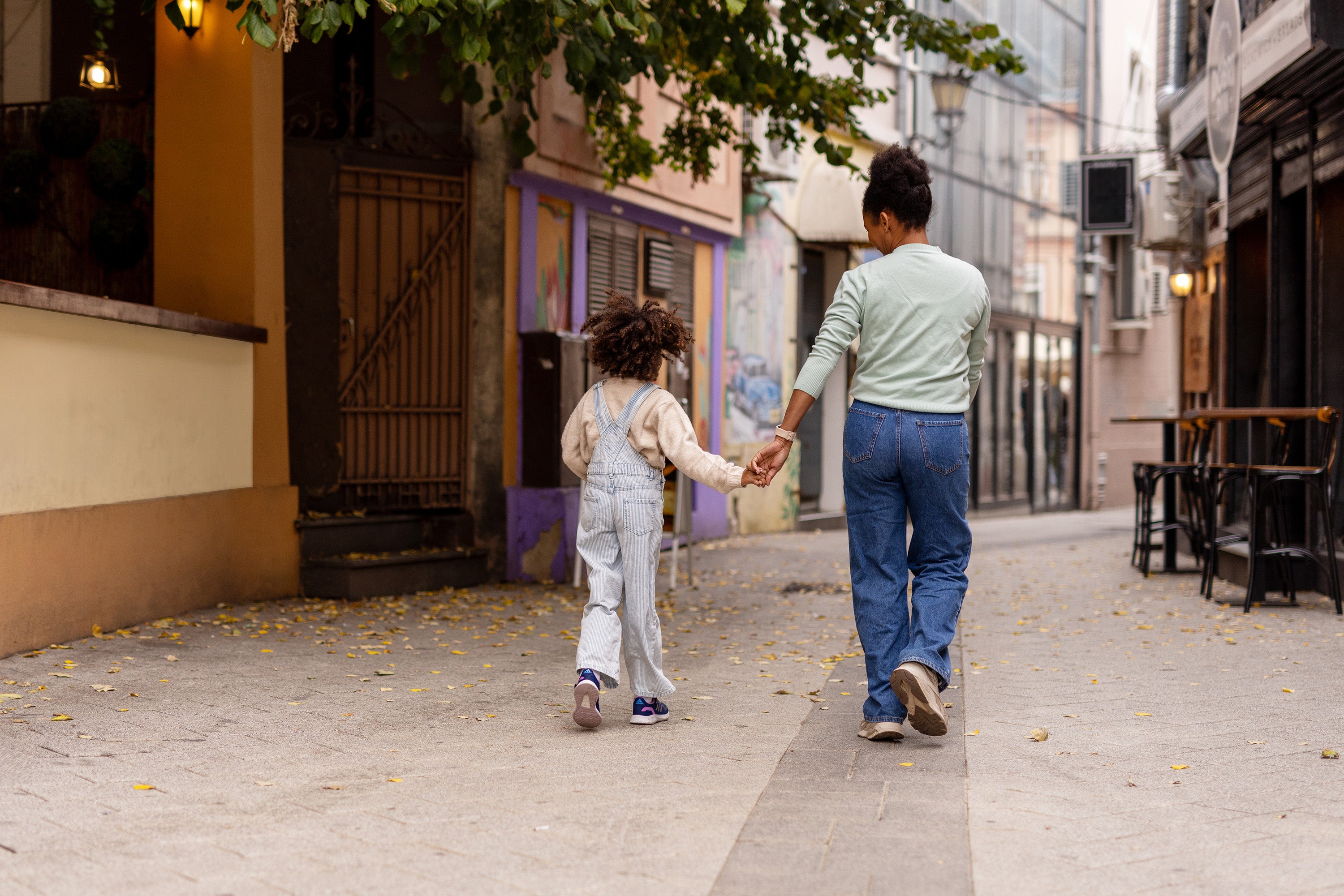 Joyful Black Mother and Little Girl Bonding While Walking Side by Side