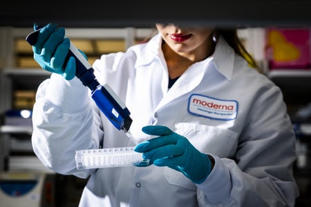 A lab tech in a white coat with a pipette