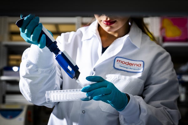 A lab tech in a white coat with a pipette