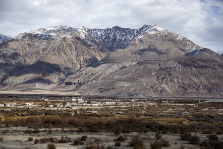 Modern buildings stand in the flood plains of the Nubra Valley, where the Nubra river flows into the Shyok river as part of the Indus River system, that separates the Ladakh and Karakaoram ranges in Nubra, Jamma and Kashmir, India, on Thursday, Nov. 14, 2019. Mountains are seen in the background.