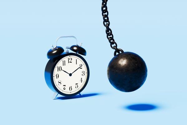 A wrecking ball poised to strike an alarm clock on a blue background