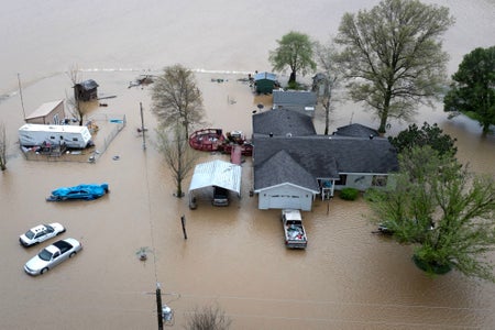 Aerial view shows floodwaters surrounding a rural home.