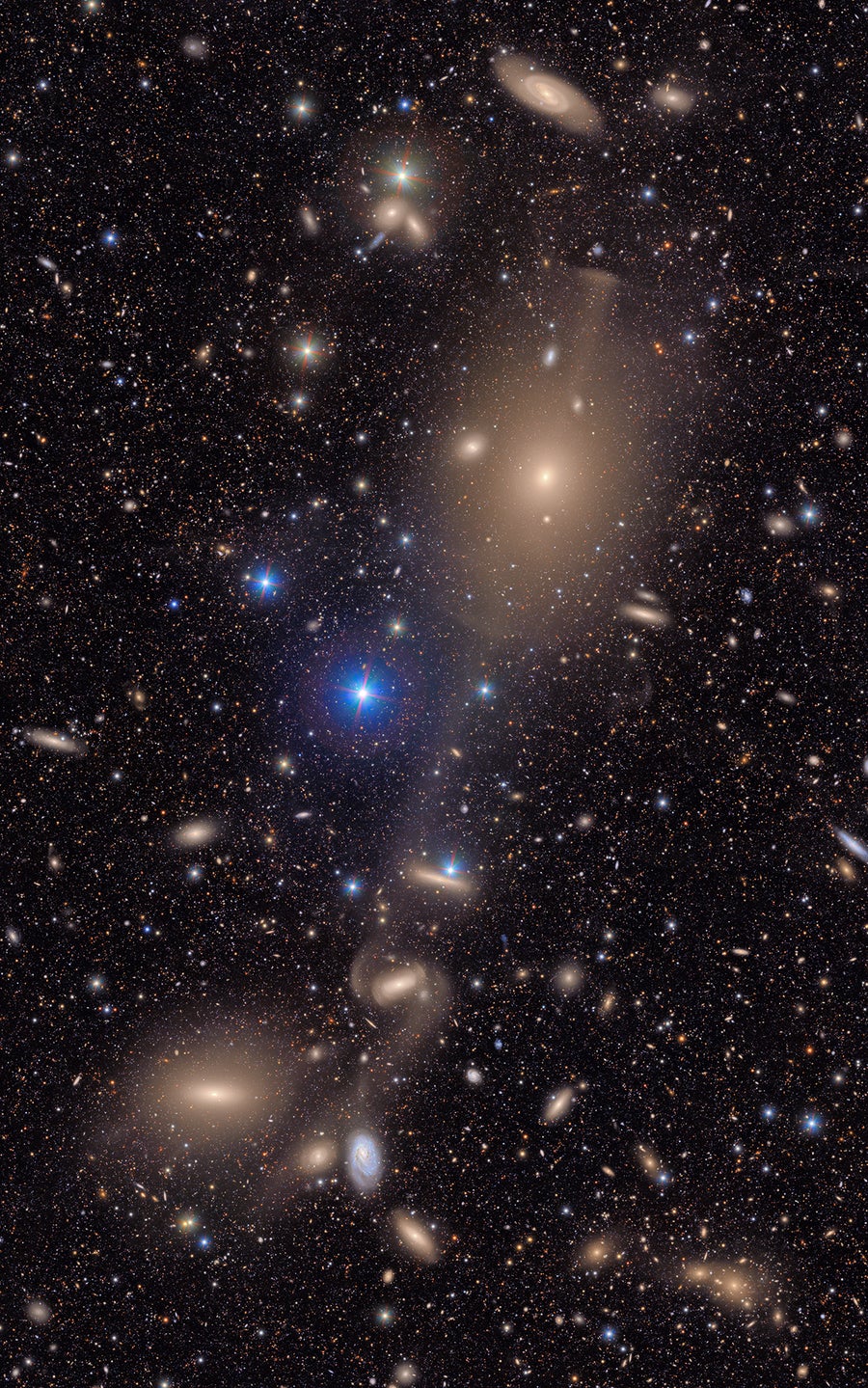Estrelas brilhantes na Via Láctea brilham em primeiro plano e muitas galáxias distantes estão em segundo plano