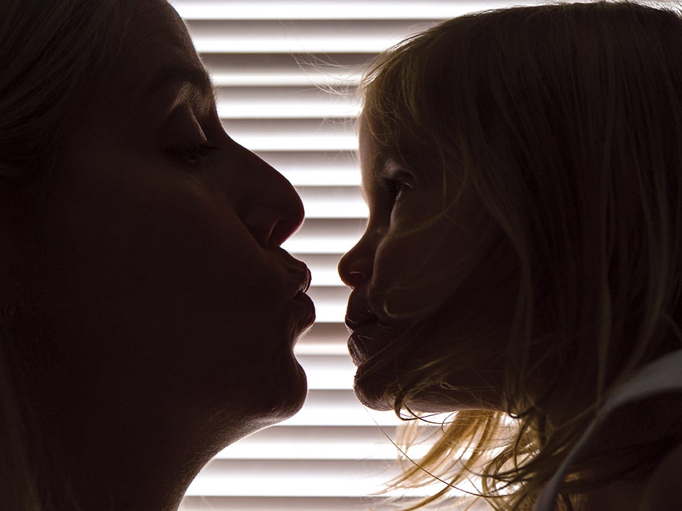 A woman leans in to kiss a child