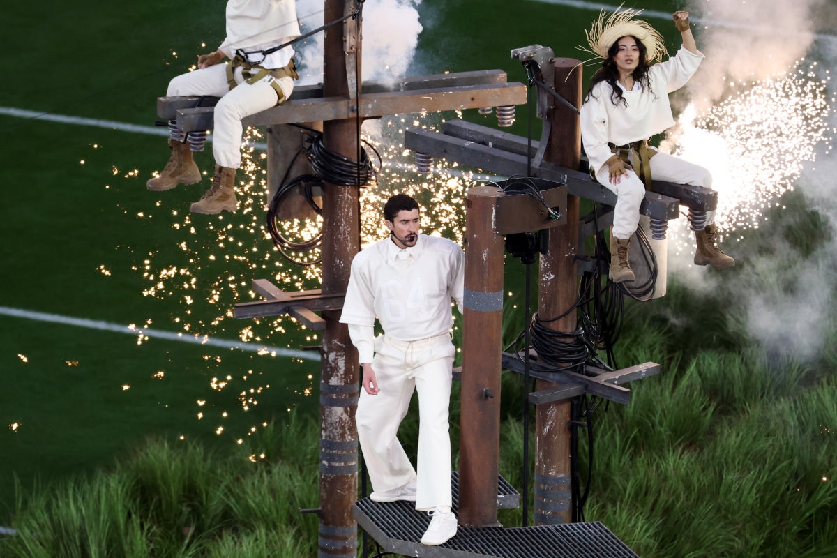 Musician Bad Bunny and dancers performing on a makeshift electric pole with sparks flying