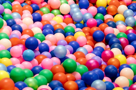 Colorful ball pit balls spanning the frame in a random arrangement.