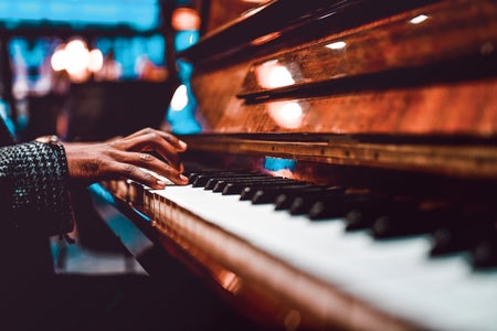 close up of person playing the piano. Only hands and the keyboard are visible.