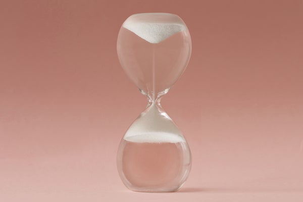 Upside-down hourglass on color background, concept of reverse time