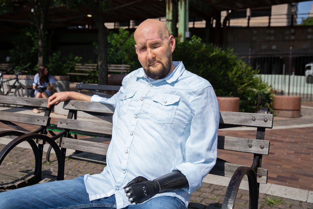 Portrait of Aaron James sitting on a park bench in New York City