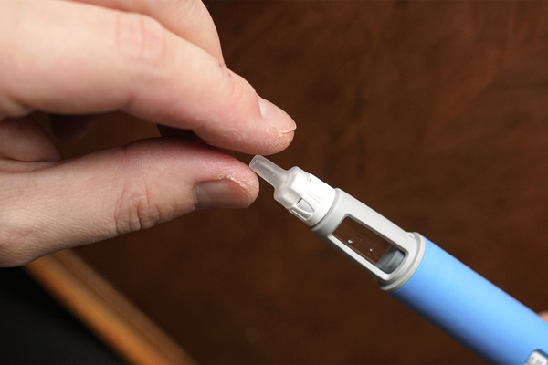 Close up of hand preparing Ozempic injection