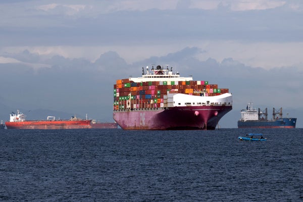 Cargo ship flanked by two other vessels on left and right.