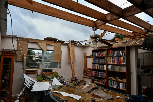 Photograph of a living space inside a private home with the roof missing after a tornado passed through the area