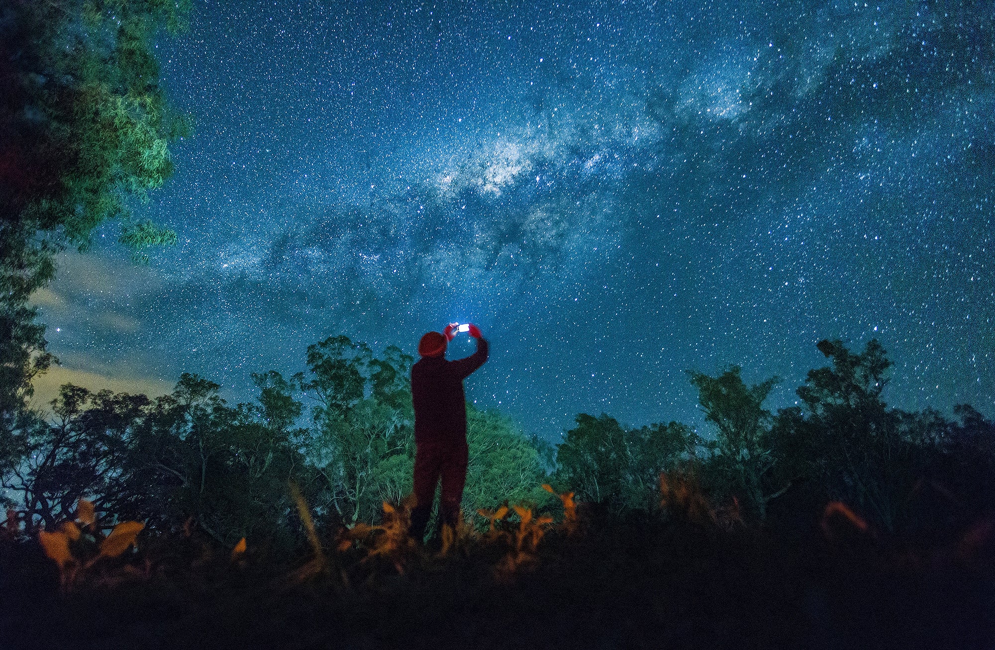 Man taking photo of night sky with smartphone