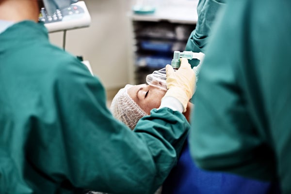 Shot of an anesthesiologist and surgeons working on a patient in an operating room