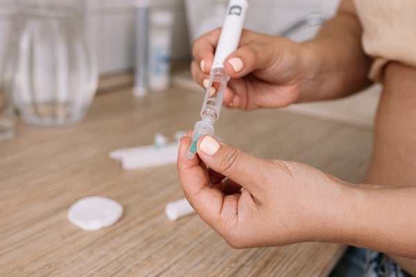 Person holding semaglutide injection pen over a countertop