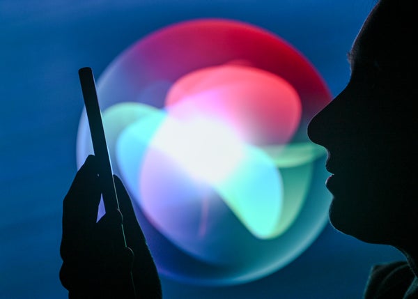 Person holding phone w/ SIRI logi in background