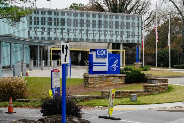 A glass-walled building entrance fronted by CDC signs