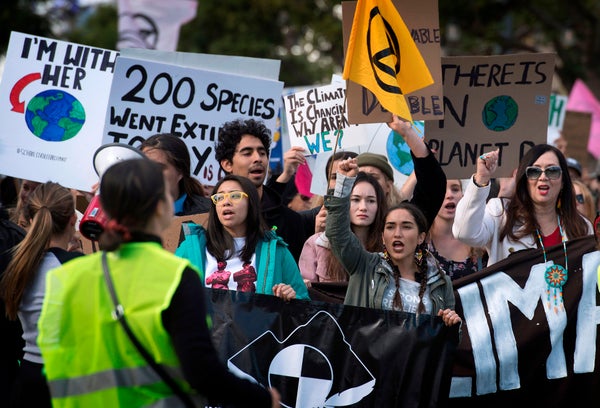 A group of people holding signs with climate action messages.