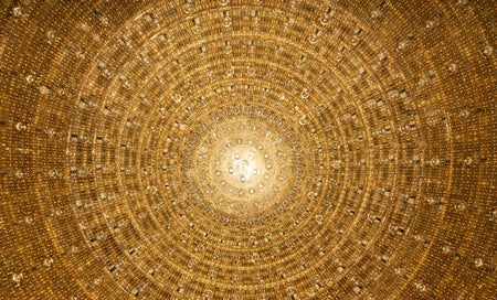 A circle of gold photomultiplier tubes that are part of the JUNO neutrino observatory.