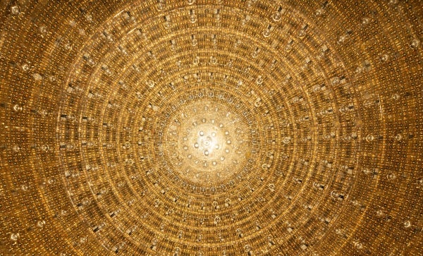 A circle of gold photomultiplier tubes that are part of the JUNO neutrino observatory.