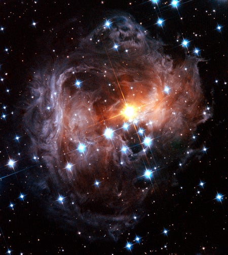 Colorful spiral dust clouds surround glowing central star