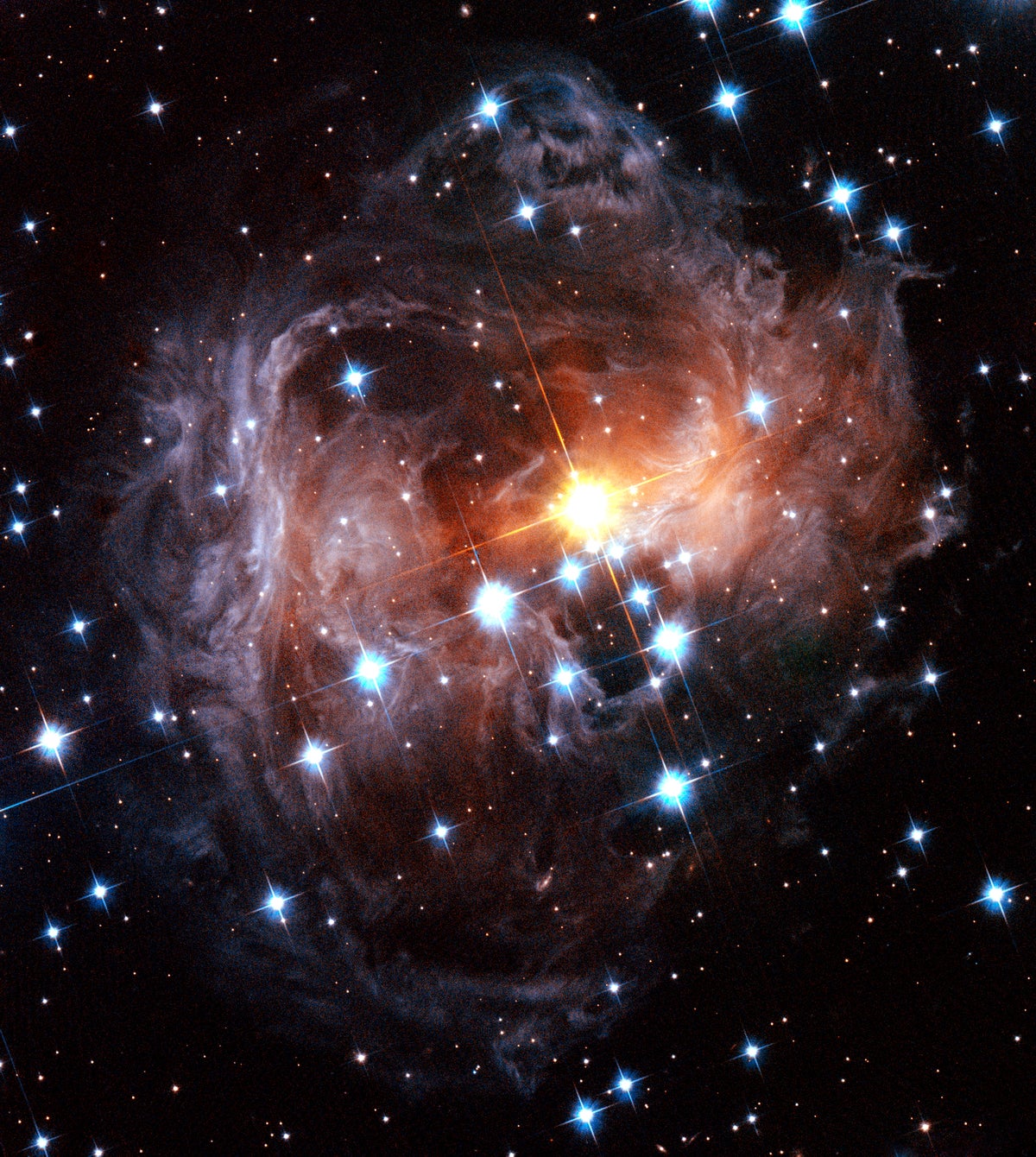 Colorful spiral dust clouds surround glowing central star
