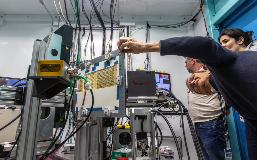 Научници посматрају како синхротрон у Националној лабораторији СЛАЦ сија својим рендгенским снопом на страници рукописа.