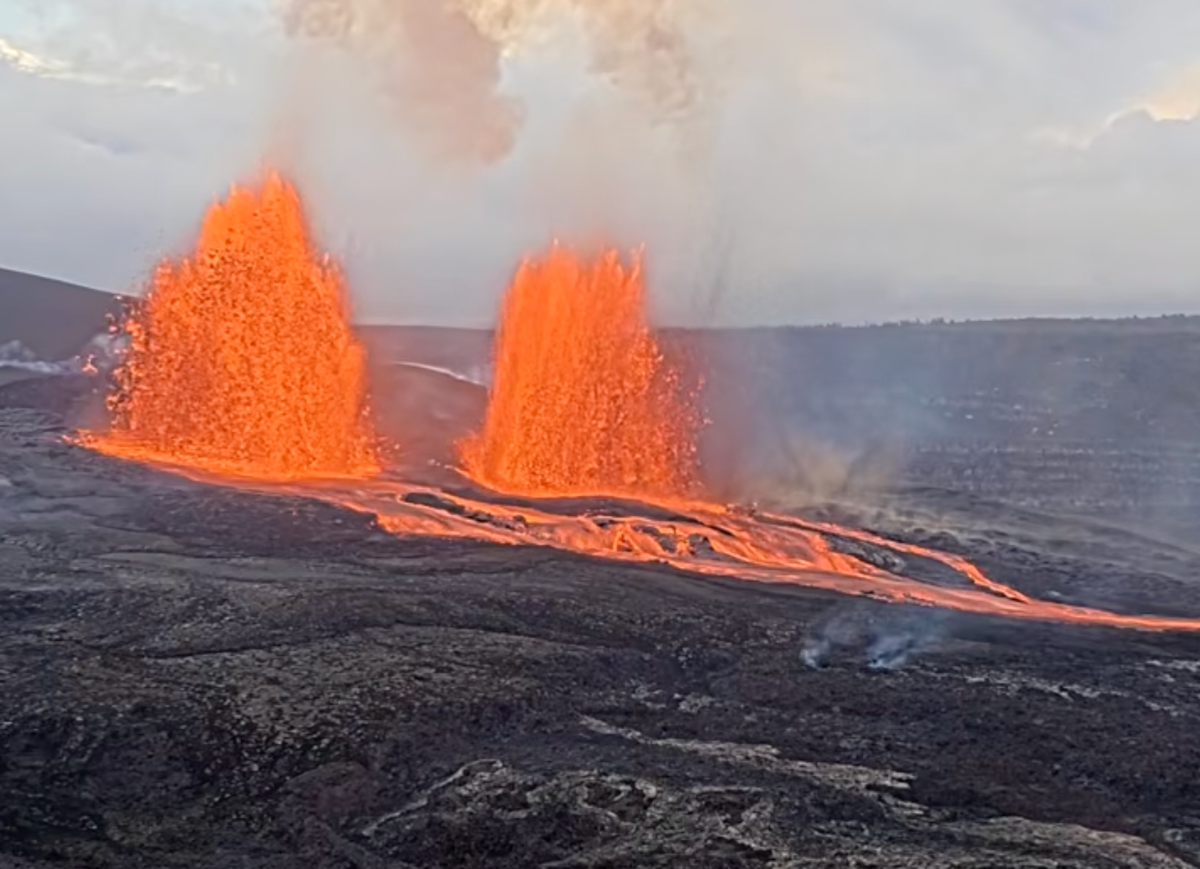 Kīlauea volcano in Hawaii is seen mideruption, with two large plumes of lava jetting into the sky