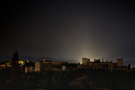 A view of the starry Alhambra sky and the darkened landscape of Granada, Spain during a blackout below as a widespread power outage strikes Spain and Portugal on April 28, 2025