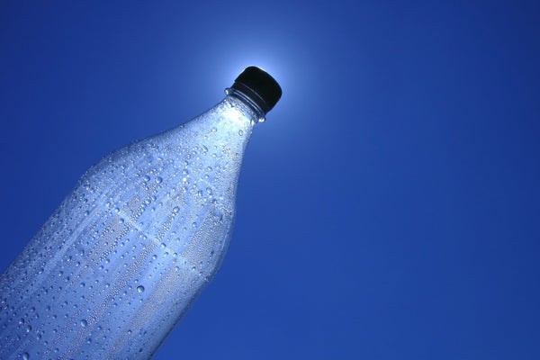 Bottle of water with condensation and blue sky as background
