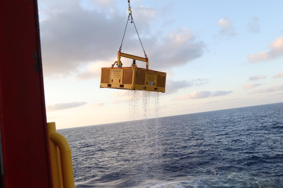 A basket carrying two Canaanite storage jars breaches the surface of the Mediterranean Sea, after their ascent from the seafloor on May 30, 2024.