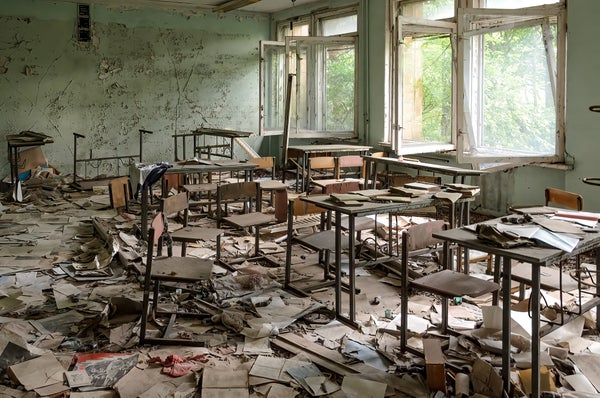 Classroom with scattered desks and books on the floor