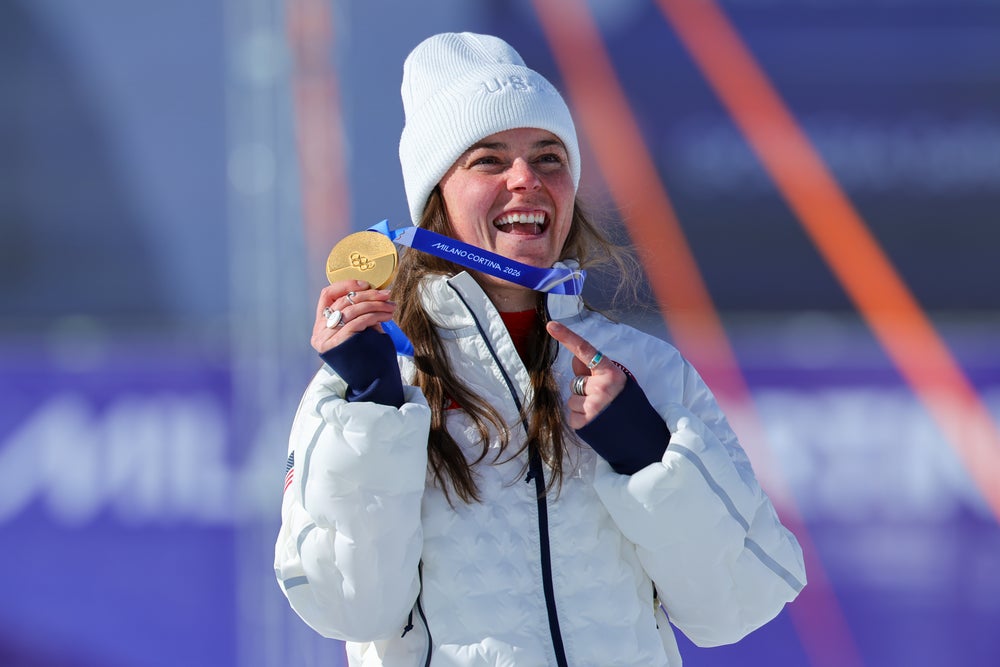 Breezy Johnson sonríe mientras sostiene su medalla de oro en los Juegos Olímpicos de Invierno Milán Cortina 2026