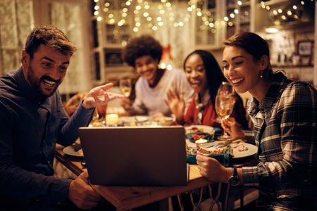 A photo of people at a Thanksgiving dinner talking to a computer.