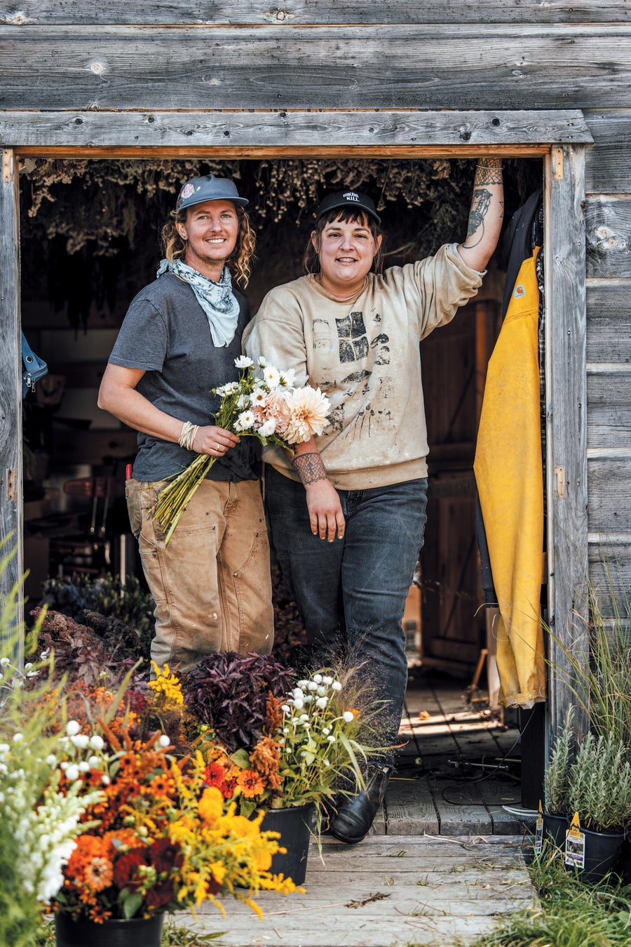 Two people standing in a shed, with flowers