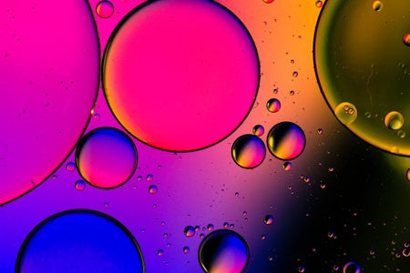 A close-up view of bubbles in liquid with bright color background.