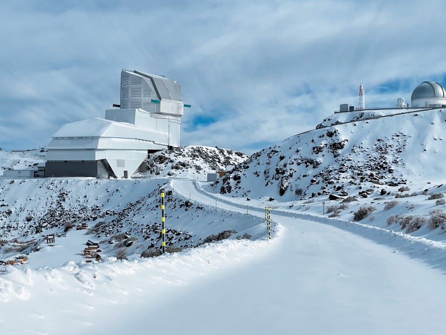 An observatory sat atop a mountain range covered in snow