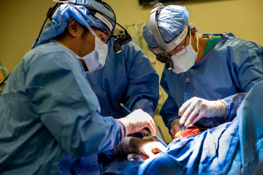 two doctors perform surgery on a patient