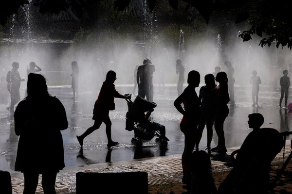 Silhouette of peole cooling off in a park in Madrid.