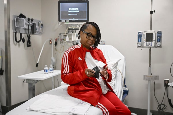 Patient in red track suit sitting on hospital bed