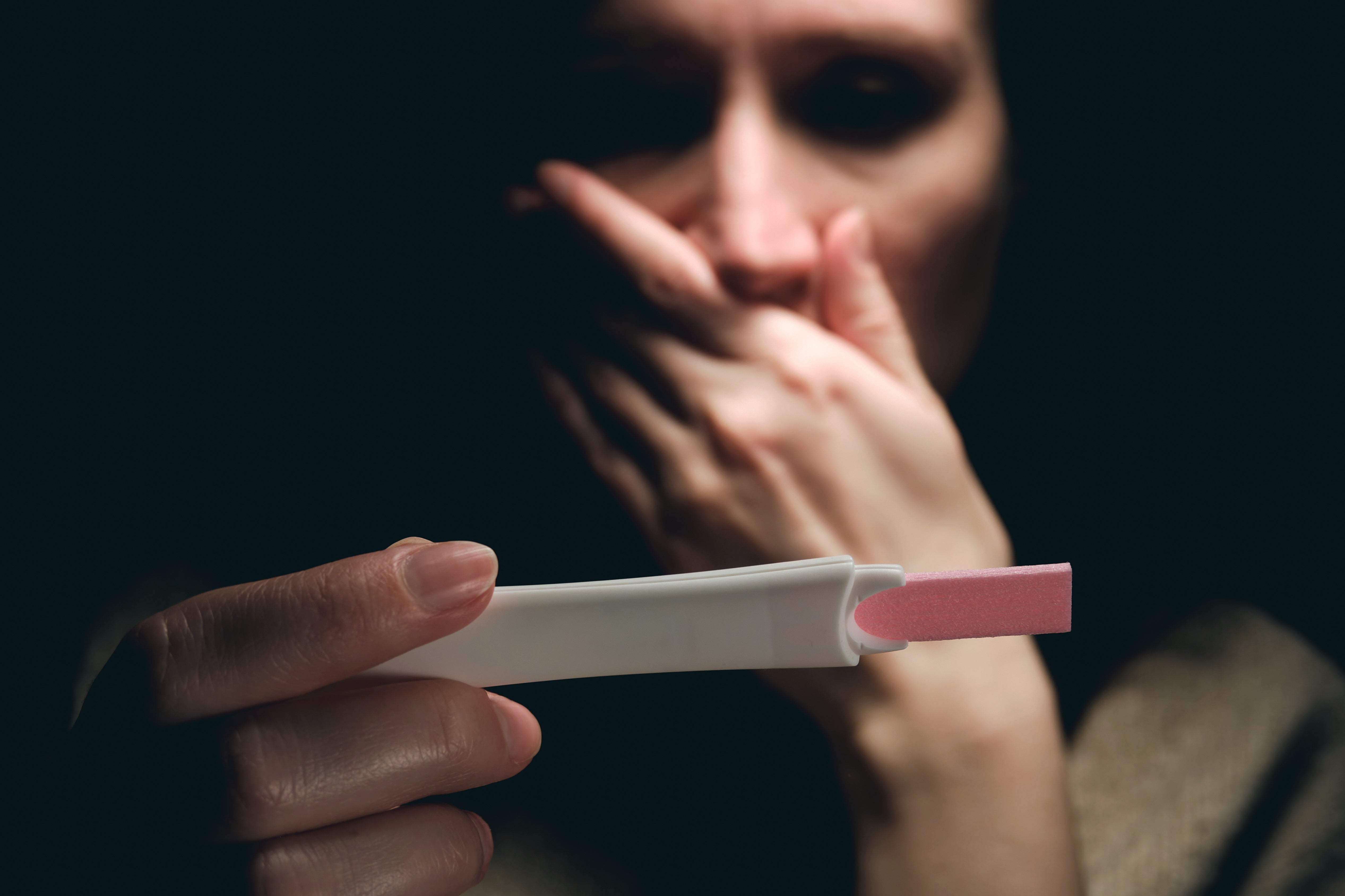 A woman seems to have a negative reaction after viewing a pregnancy test