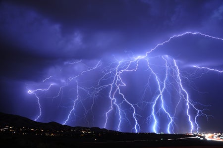 dozens of strokes of lightning over a mountain