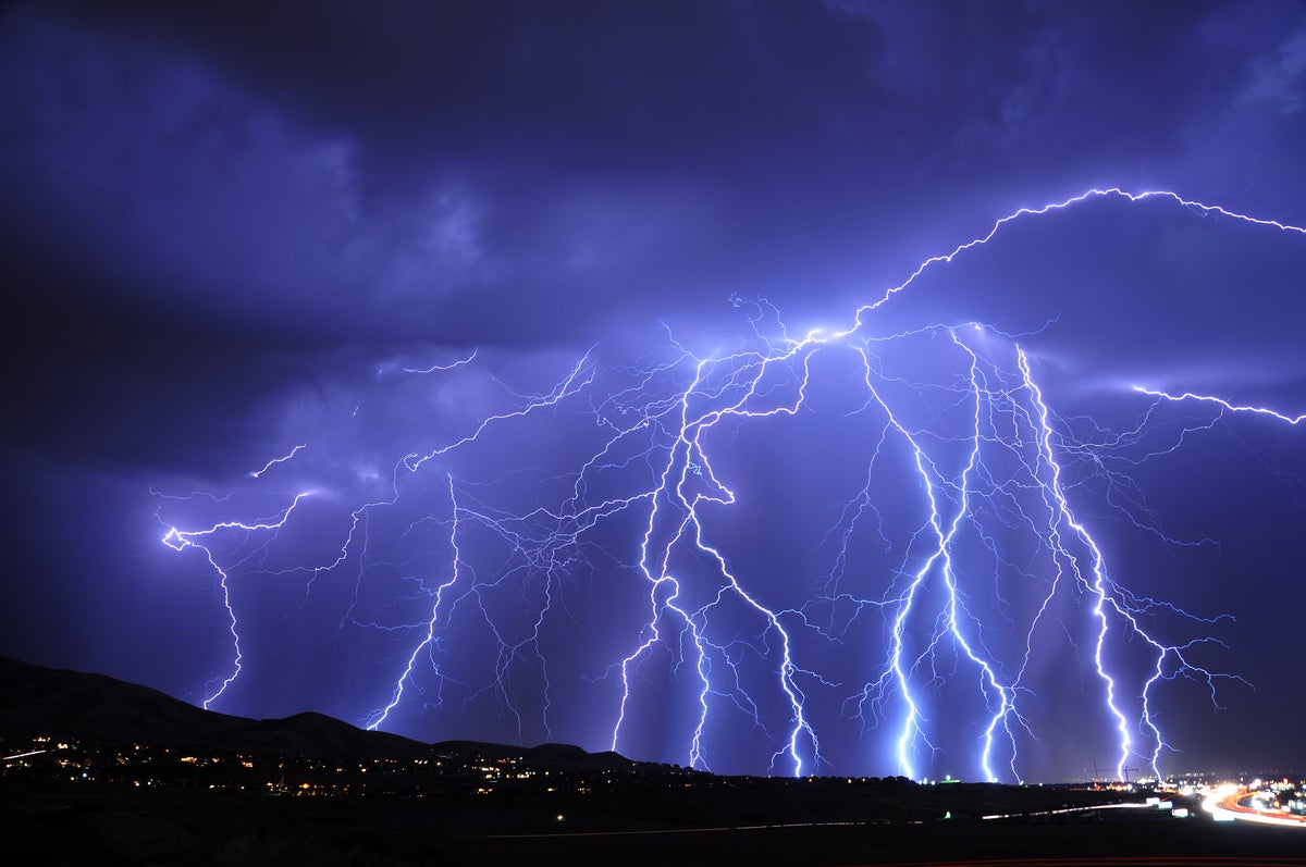 dozens of strokes of lightning over a mountain