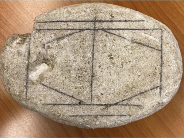 A stone with gray lines in the shape of an octagonal diamond inside a rectangle shape