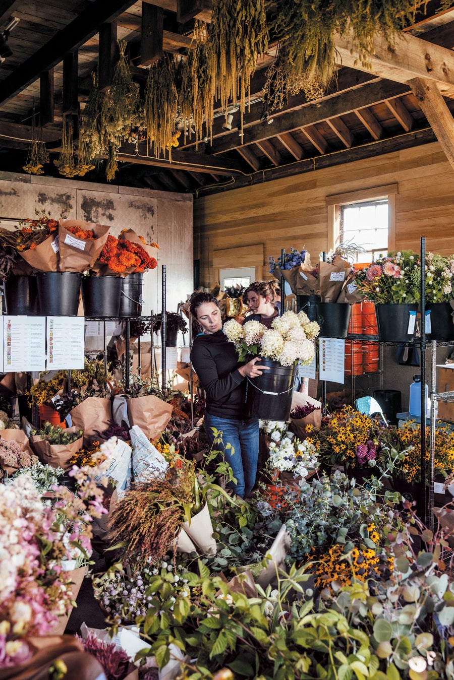 A woman carrying dahlias in crowded room