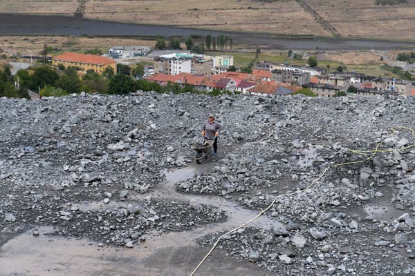 Wide-angle view of person pushing wheelbarrow through chromium mine