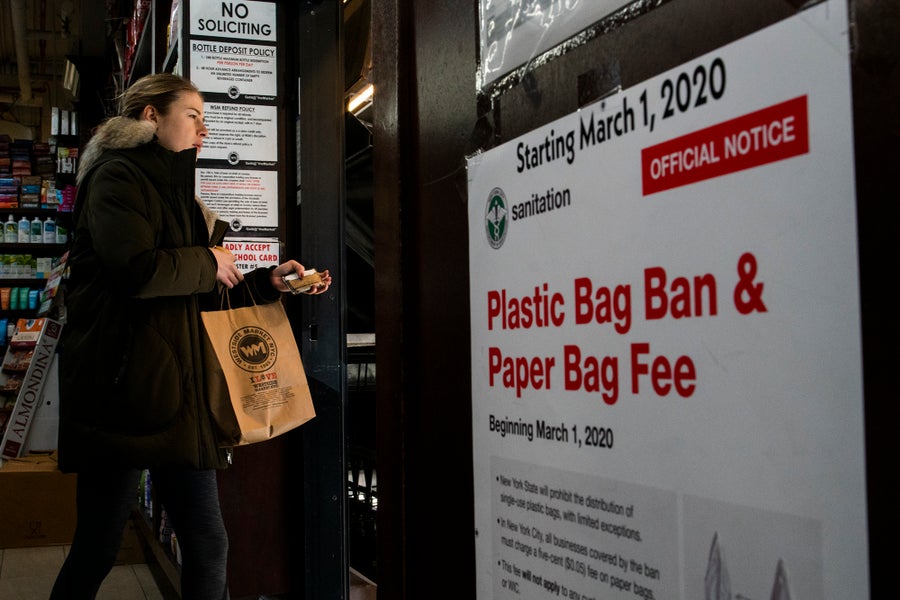 Customer walks past plastic bag ban signage in store