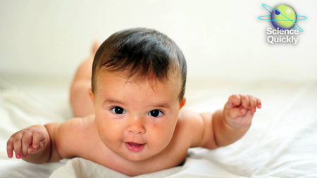 A baby laying on their tummy with their arms up.